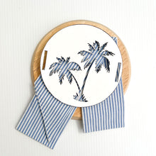 Load image into Gallery viewer, Stone colour coastal cushion with blue and white stripe sash. A tropical inspired cushion with the palm tree motive can be used in your costal home. Timber Palm Disk
