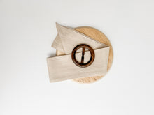 Load image into Gallery viewer, white 100% cotton cushion cover with the option of a generous feather insert. Wrapped around the cushion is a stone colour Buckle Sash and small Timber Buckle. Classic style cushion
